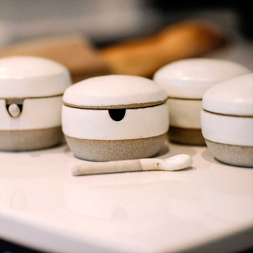 4 mains de sel béton sur comptoir avec couvercles et cuillère