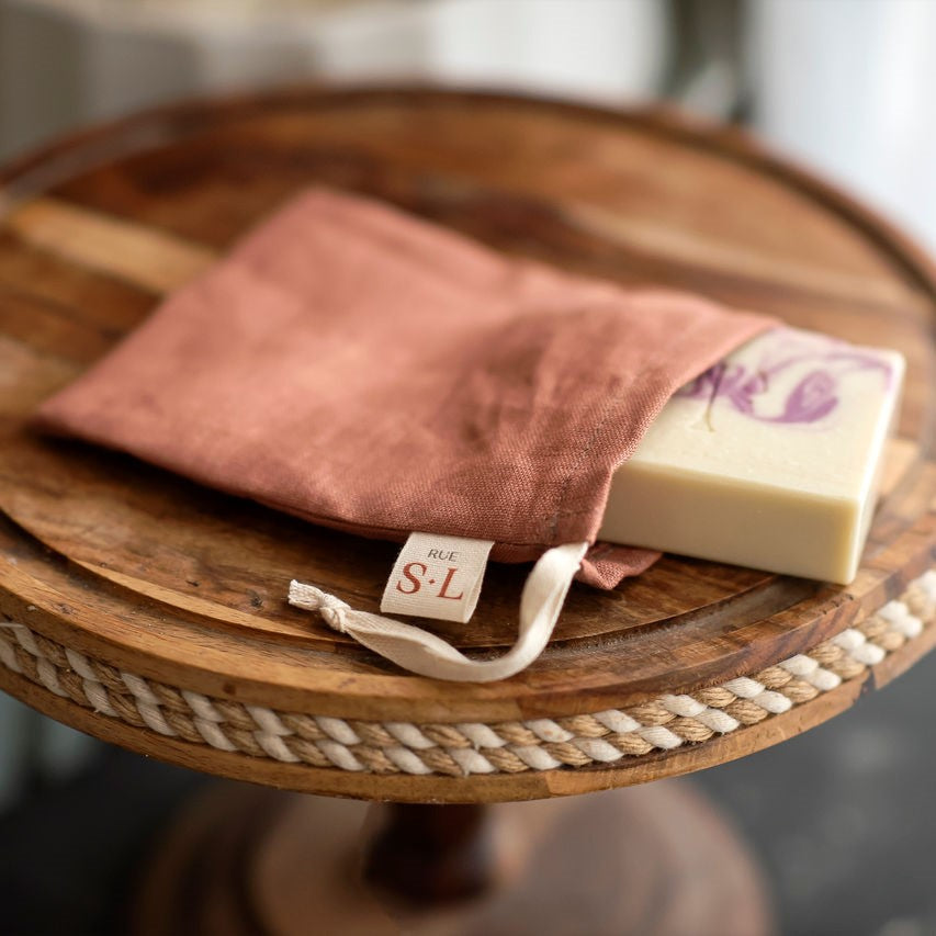 Pochette toscane sur présentoir en bois avec savon blanc et mauve