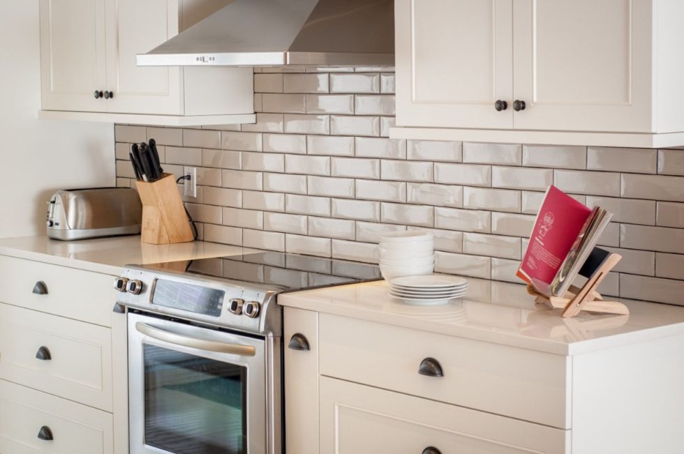 une cuisine avec des armoires blanches et des comptoirs blancs.