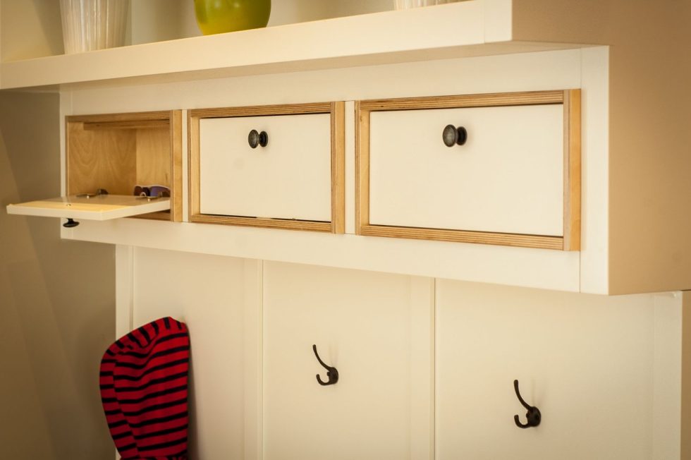 une étagère blanche avec des tiroirs et une étagère avec des crochets.