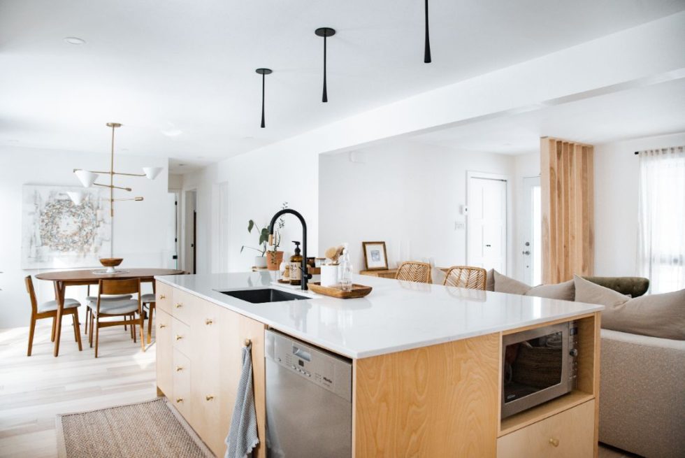 une cuisine avec un comptoir blanc et une table à manger.