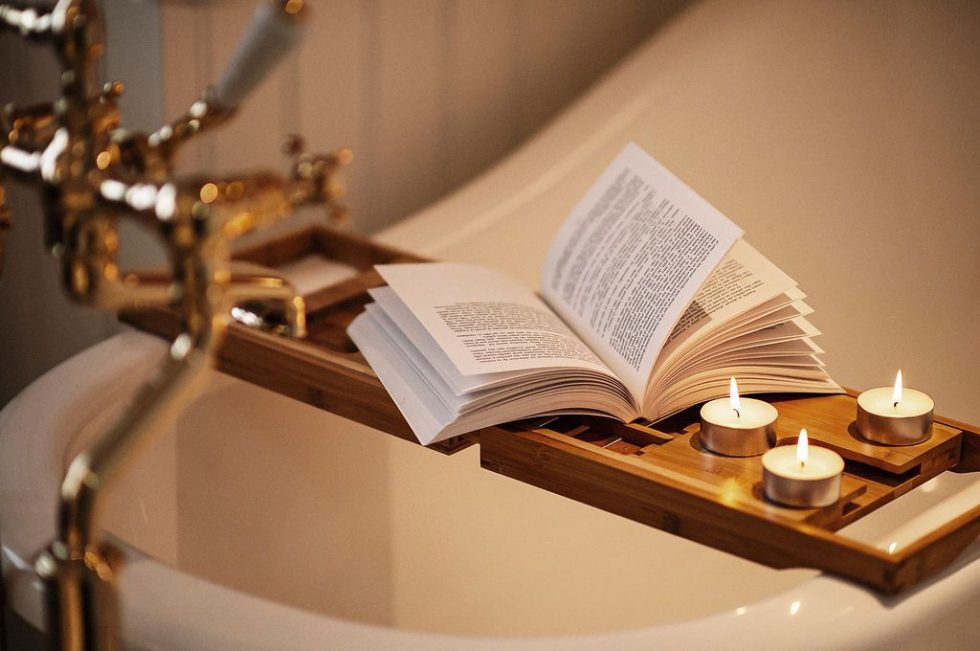 un livre et des bougies sur une baignoire.