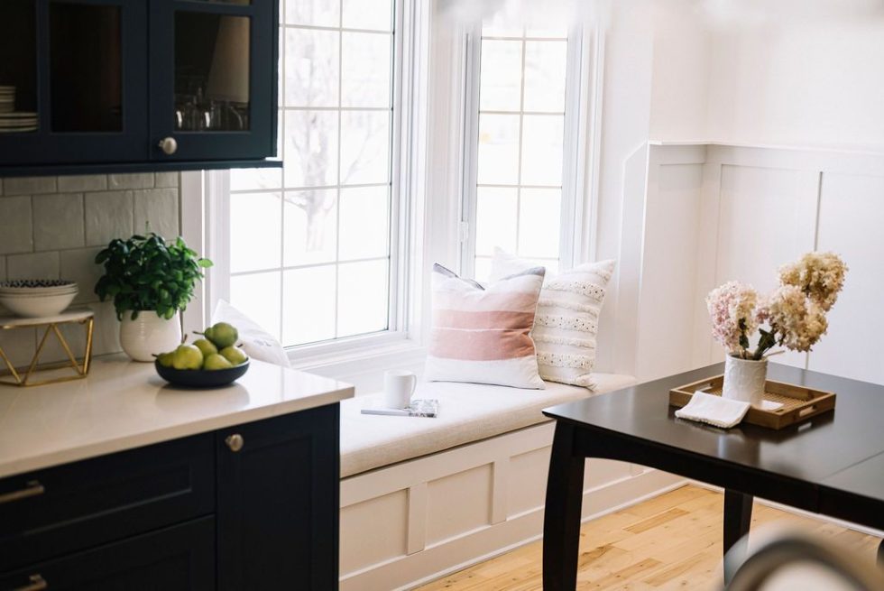 une cuisine avec un siège de fenêtre et une table.