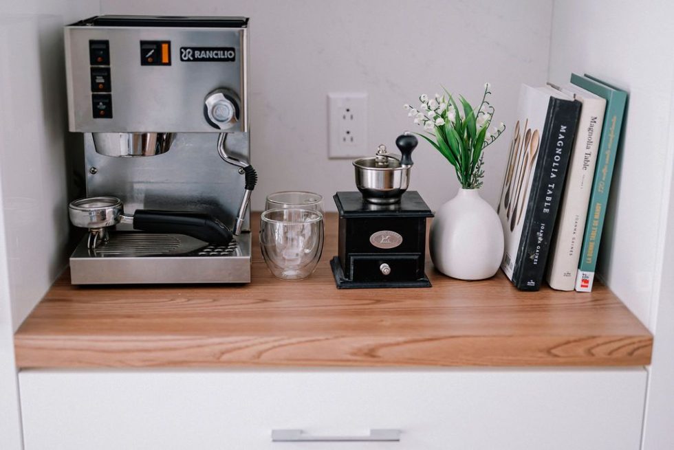 une machine à café et un vase de fleurs sur un comptoir.