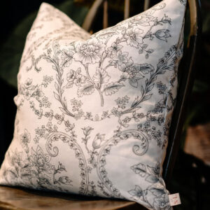 Coussin crème et noir sur chaise en bois.