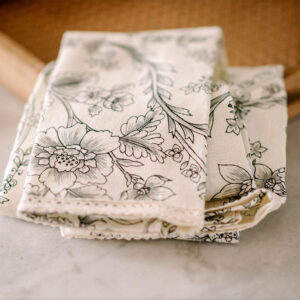 Linges à main de couleurs noire et crème dans boîte en bois sur comptoir en marbre.