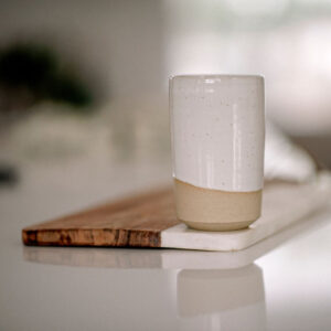 Grand gobelet en céramique sur planche de bois et marbre.