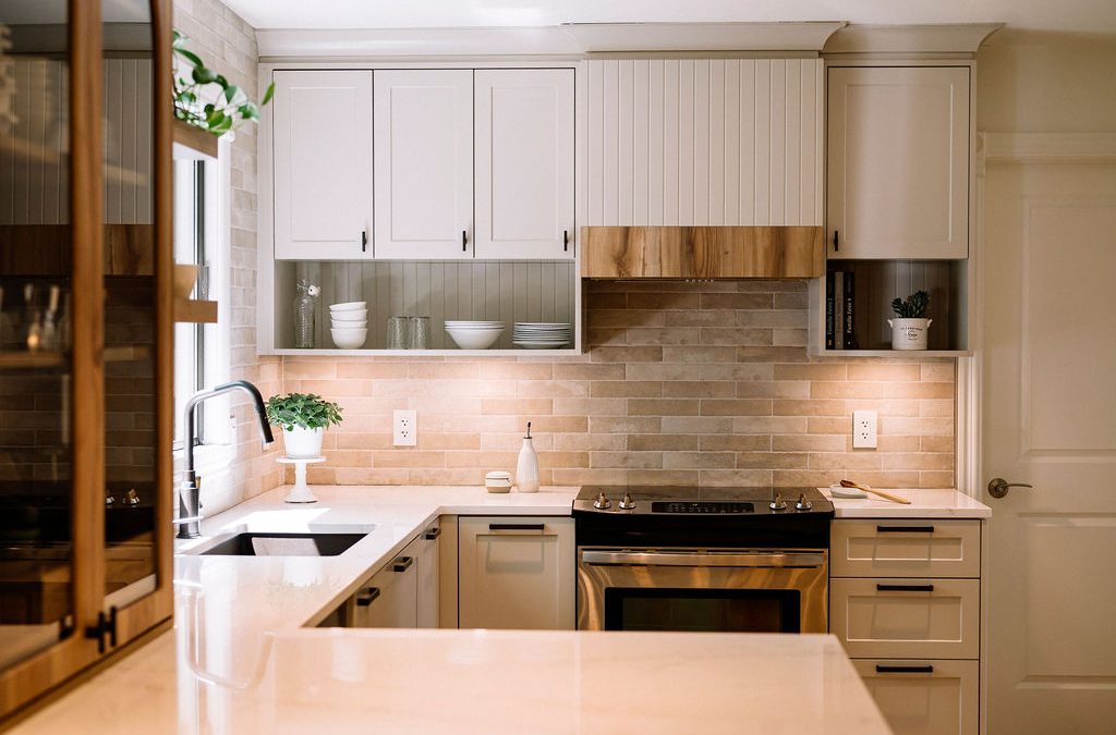 Cuisine élégante avec hotte en bois, évier noir, étagères ouvertes et éclairage chaleureux sur carrelage beige